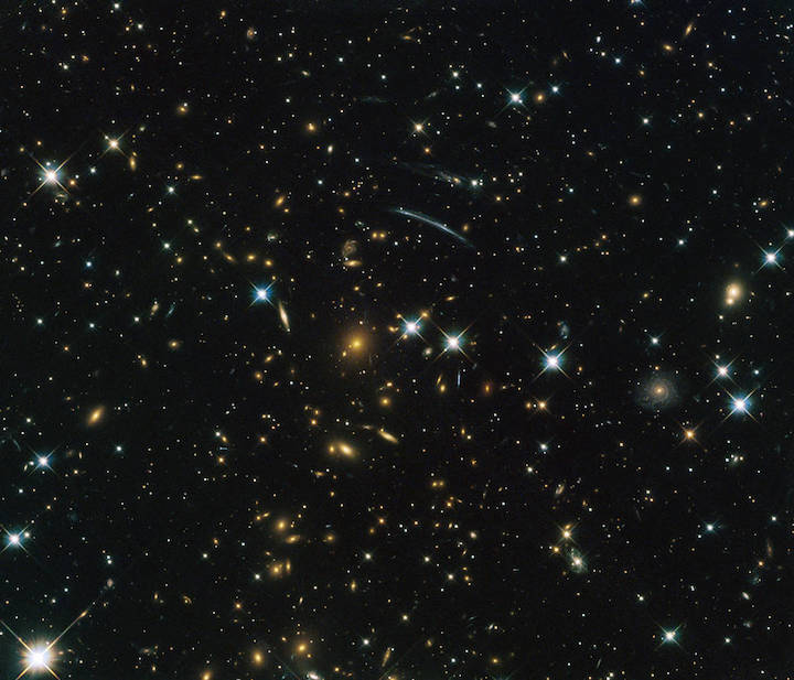 An image of hundreds of small galaxies on the black background of space.