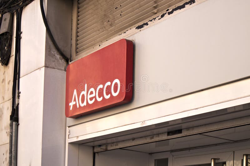 Logo on the facade of an office of the temporary employment agency Adecco stock photo