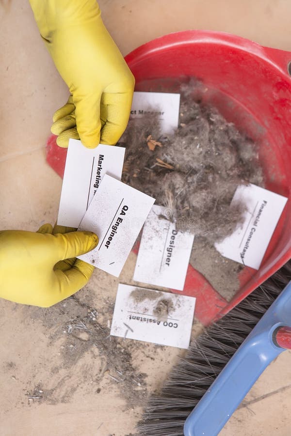 Staff reduction concept - Cutting staff and employee Job Reduction. Dismissal. Office cleaner throw in the debris staff business cards. Crisis management and stock photo