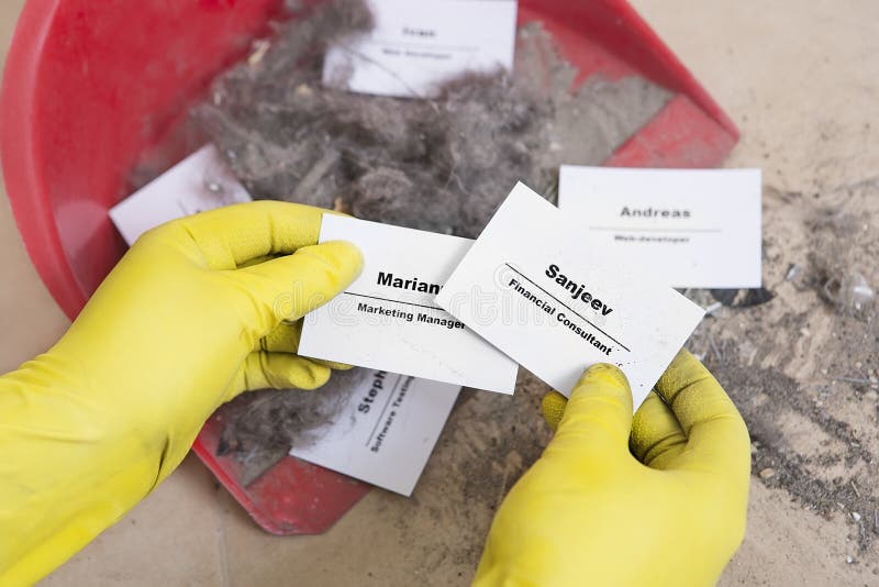 Staff reduction concept - Cutting staff and employee Job Reduction. Dismissal. Office cleaner throw in the debris staff business cards. Crisis management and stock photography