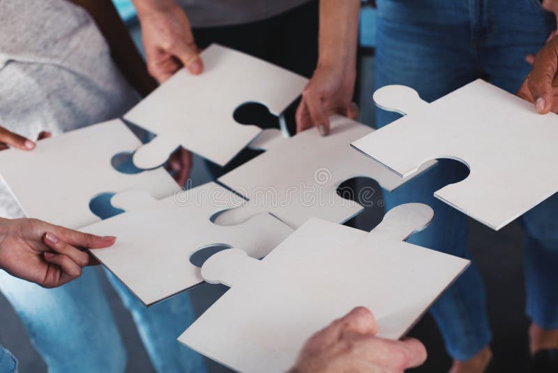 Team of businessmen work together for one goal. Concept of unity and partnership. Team of businessmen work together for one goal with puzzles. Concept of unity stock photo