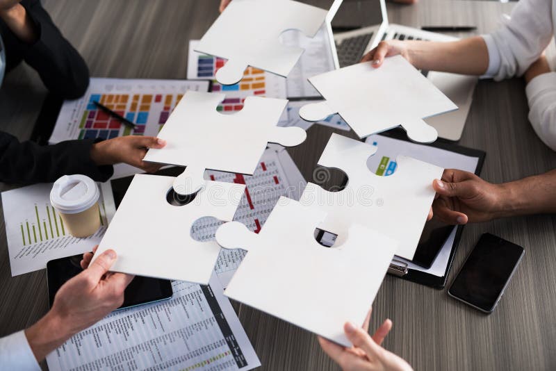 Team of businessmen work together for one goal. Concept of unity and partnership. Team of businessmen work together for one goal with puzzles. Concept of unity stock images