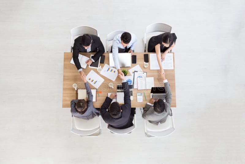 Top view of businessmen shaking hands sitting at conference table during team meeting, stock photos