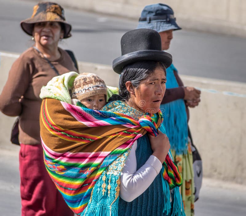 Traditional Woman Cholita in Typical Clothes with baby on her back during 1st of May Labor Day Parade - La Paz, Bolivia royalty free stock photo