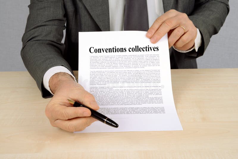 Collective agreements written in French. Unrecognizable man holding a document of collective agreements royalty free stock photo