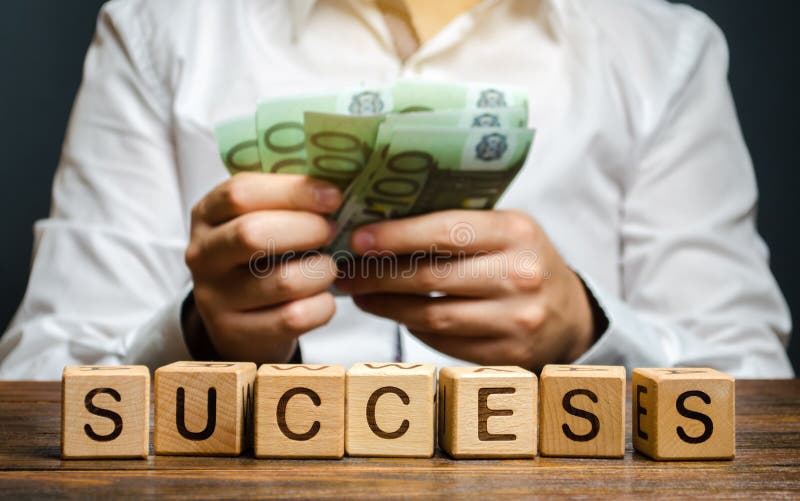 Wooden blocks with the word Success and businessman with money. Successful business concept. The growth of profits and earnings. Performance. Achieving the stock photo