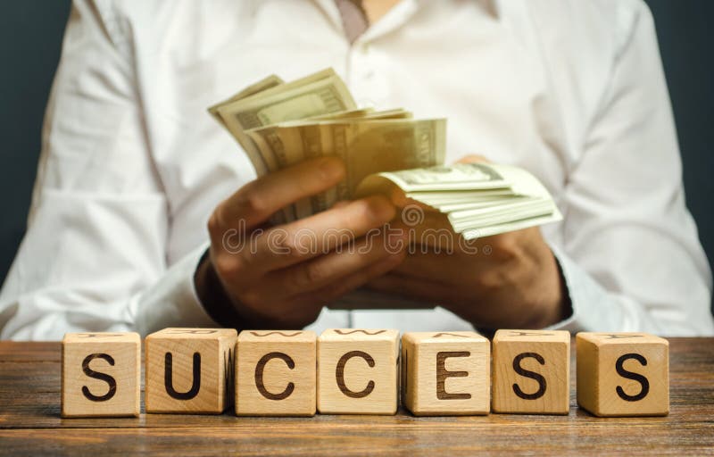 Wooden blocks with the word Success and businessman with money. Successful business concept. The growth of profits and earnings. Performance. Achieving the stock photos