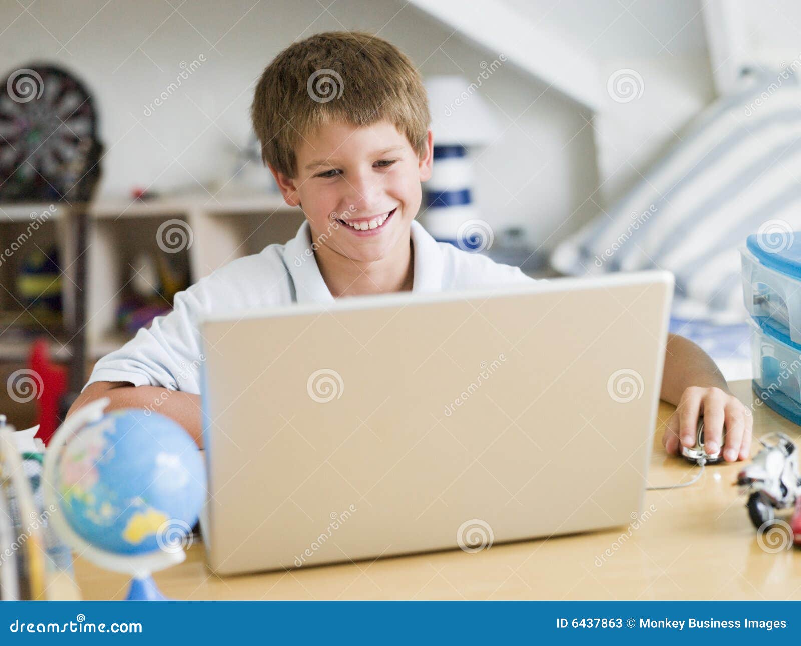 ragazzo della camera da letto il suo computer portatile usando i giovani 6437863